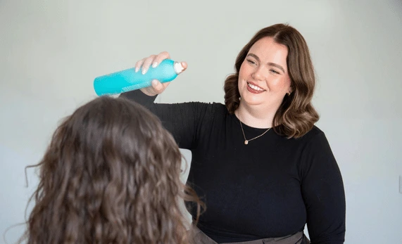 emma-victoria-applying-hairspray-to-client
